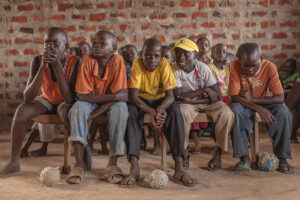 young boys classroom footballs wooden bench africa school kenya