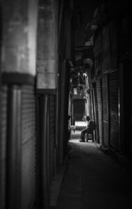 man sitting alone alley egypt nightshot black and white window covers